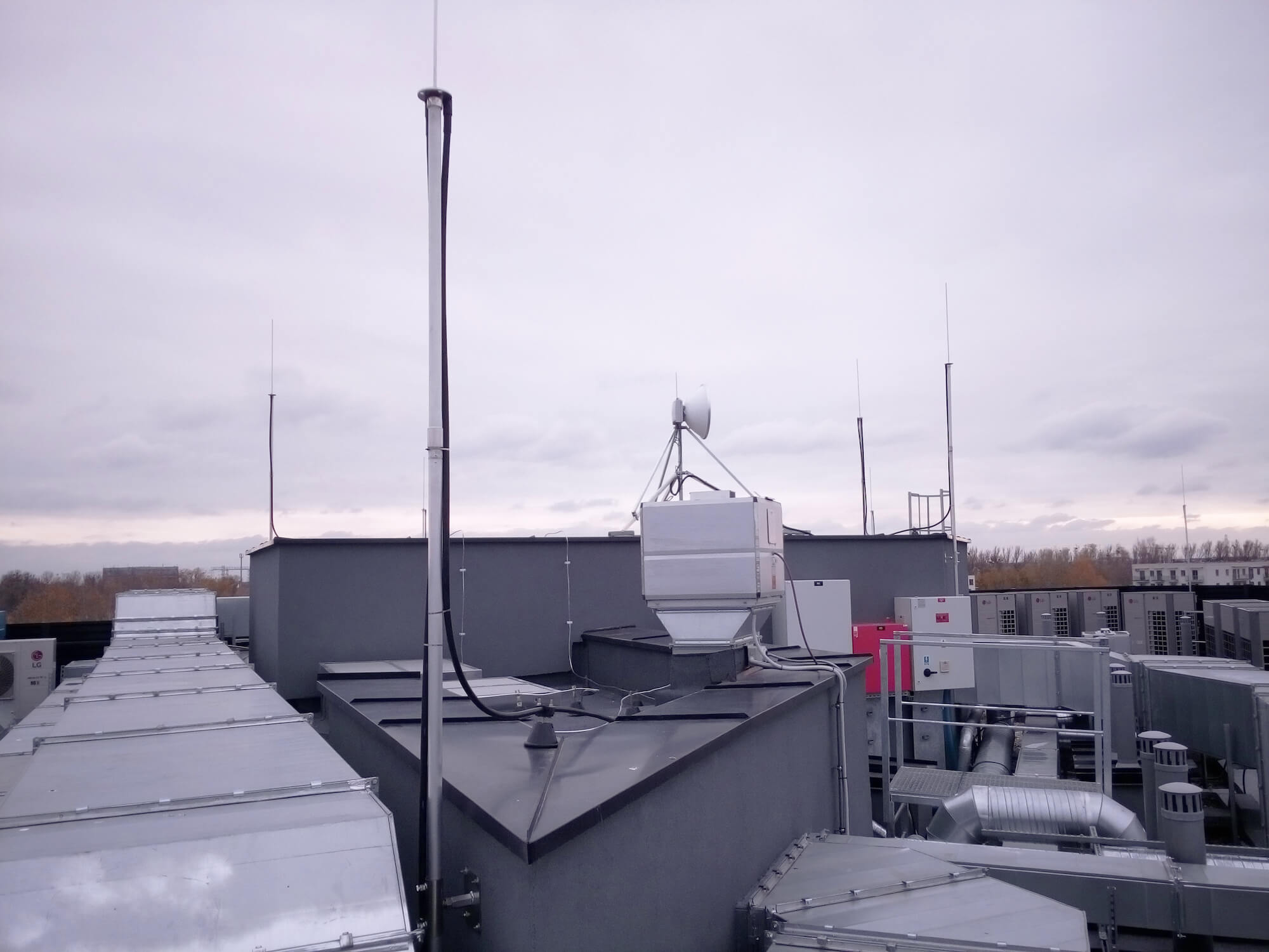 Insulated lightning protection masts with high-voltage discharge conductor attached to the structure of protective screens on the roof